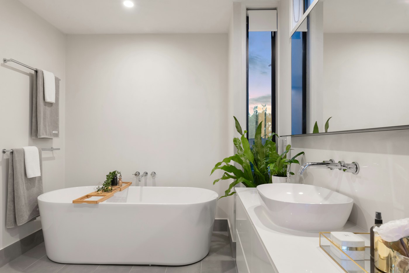 Freestanding bath beside a softly lit stone wall