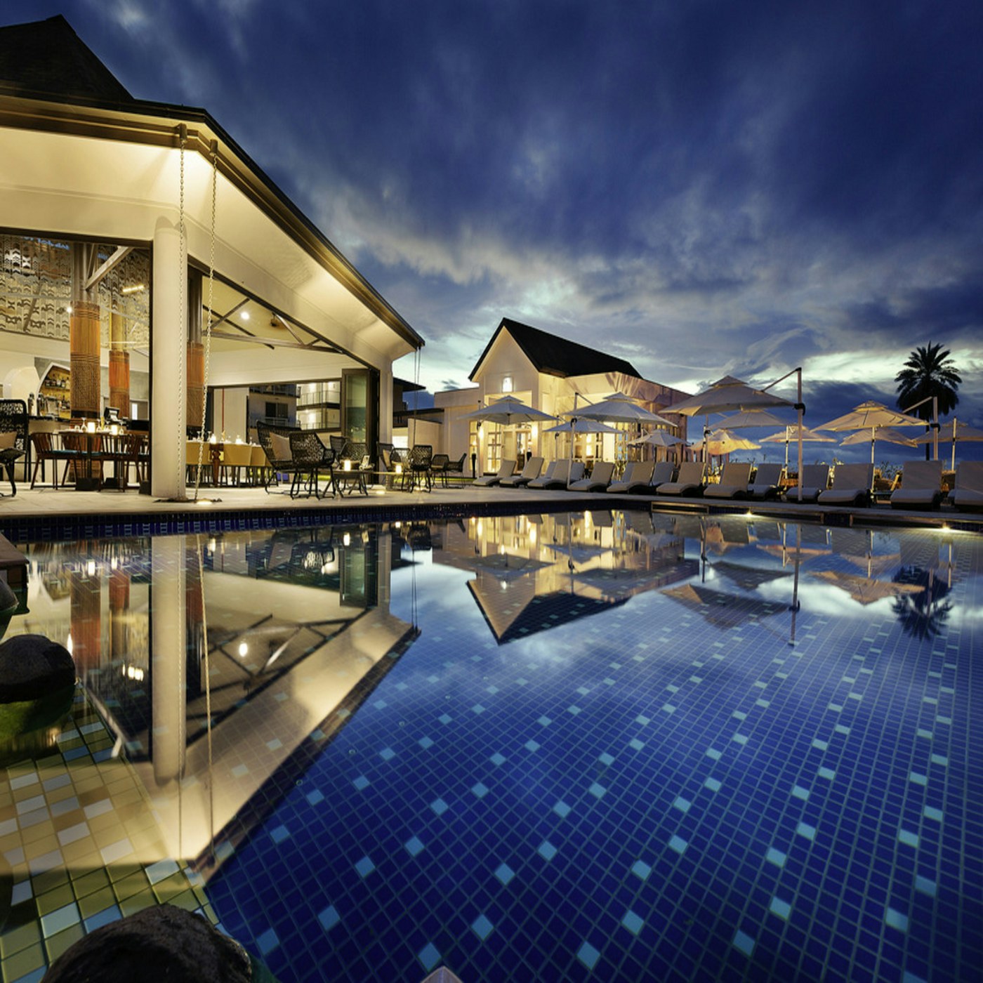 Resort pool pavilion with a calm waterline and shaded dining terrace